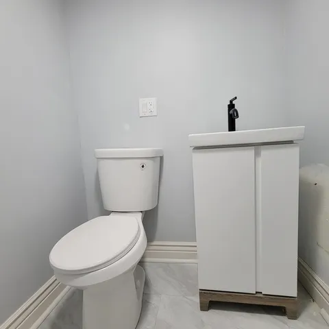 a white toilet sitting next to a white sink