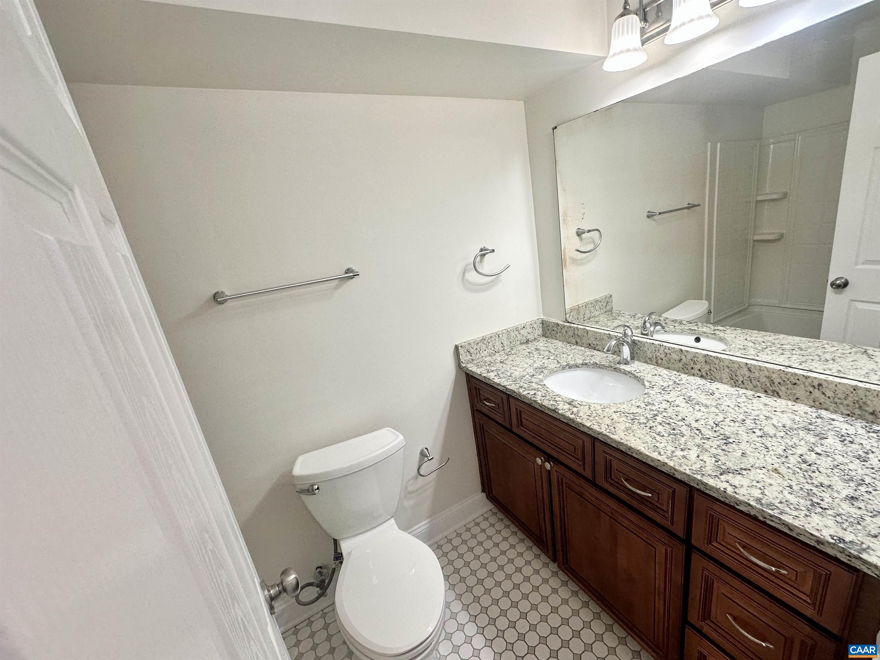 101 Turtle Creek Road, Unit 5 Charlottesville, VA 22901 - Photo 9 of 23 a bathroom with a granite countertop toilet sink and mirror