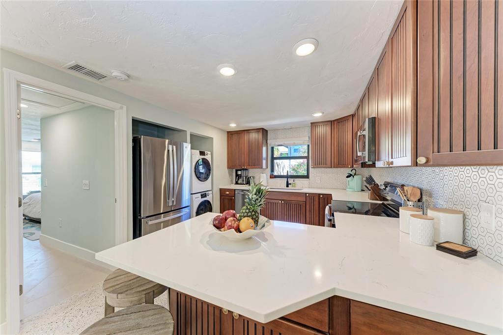 730 Fox Street Longboat Key, FL 34228 - Photo 15 of 40 a kitchen with a dining table chairs and white cabinets