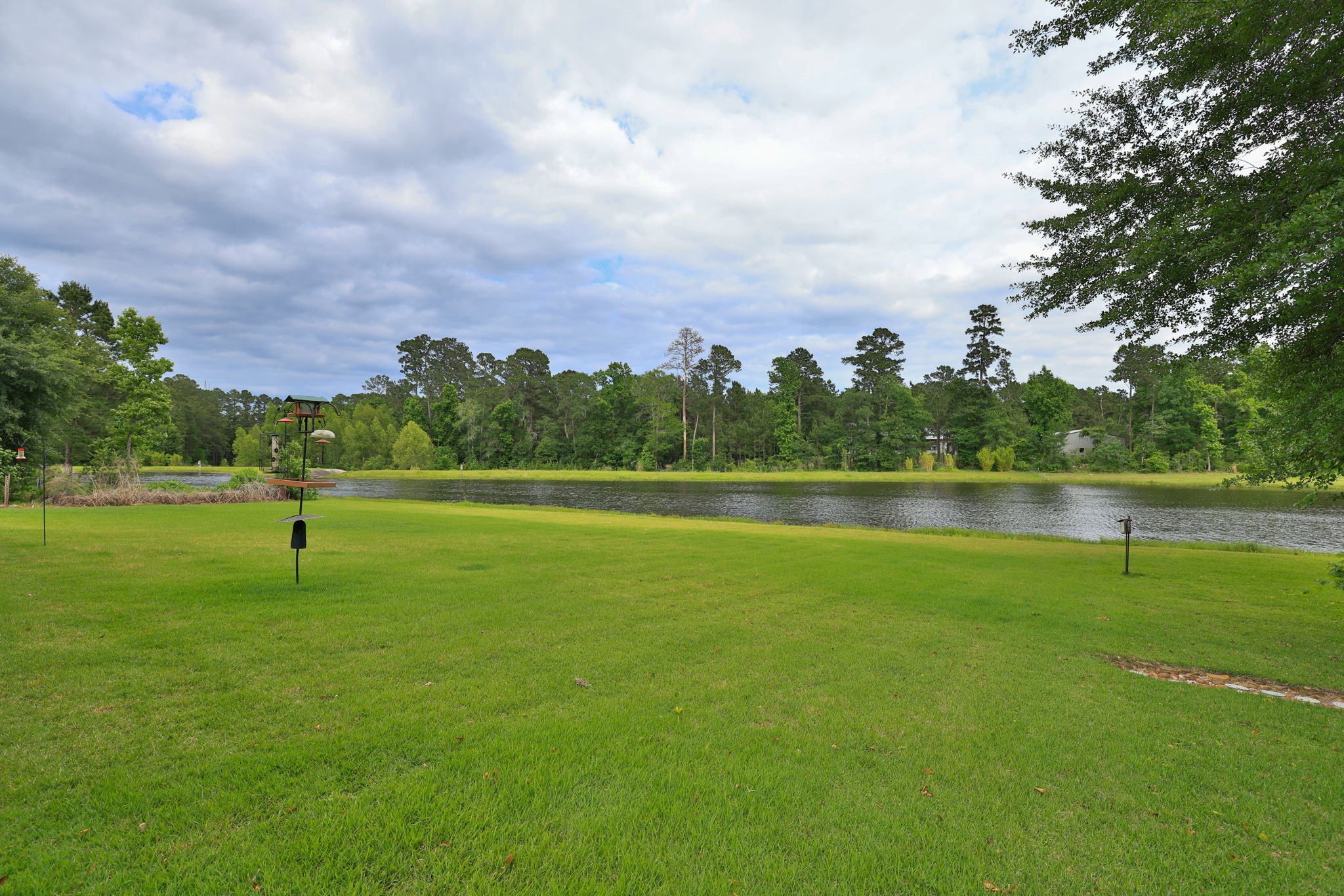 6918 Comanche Bend Montgomery, TX 77316 - Photo 4 of 50 Imagine creating your very own backyard oasis, an infinity pool overlooking the water would be absolutely beautiful. Enjoy peaceful waterfront views, stunning sunsets, and the natural beauty that surrounds High Meadow Estates. The mature trees, nature, and local wildlife create a serene setting that is hard to find and easy to appreciate. You have your very own WELL for irrigation purposes.