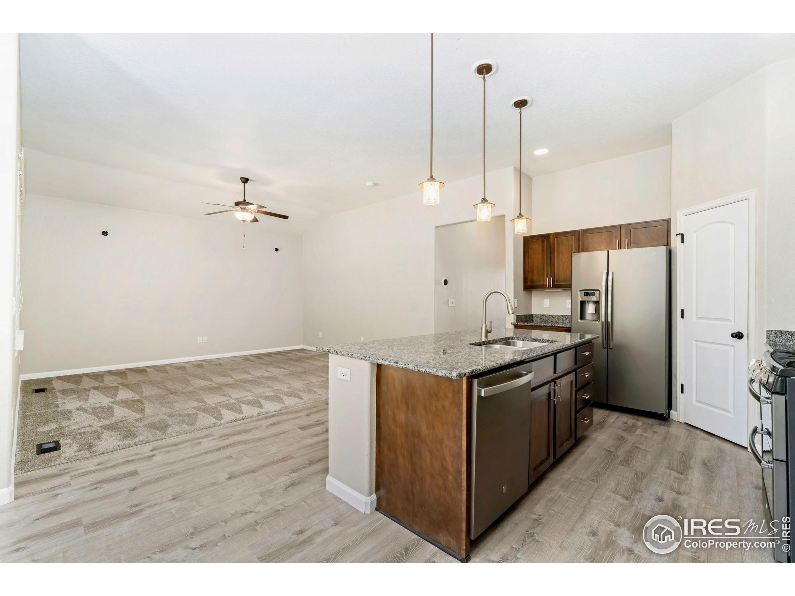 11449 Coal Ridge Street Firestone, CO 80504 - Photo 6 of 33 a kitchen with stainless steel appliances granite countertop a stove a refrigerator and a sink