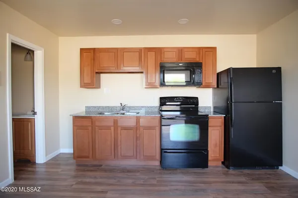 a kitchen with stainless steel appliances granite countertop a refrigerator and a stove top oven