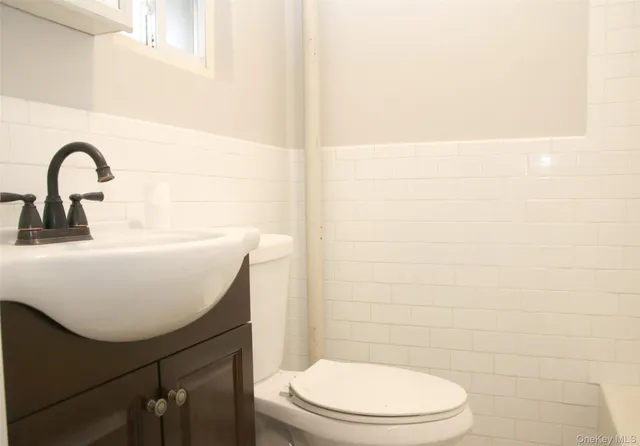 a bathroom with a sink toilet and a mirror