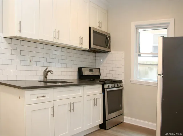 a kitchen with stainless steel appliances white cabinets and a sink