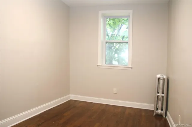 an empty room with wooden floor and a window