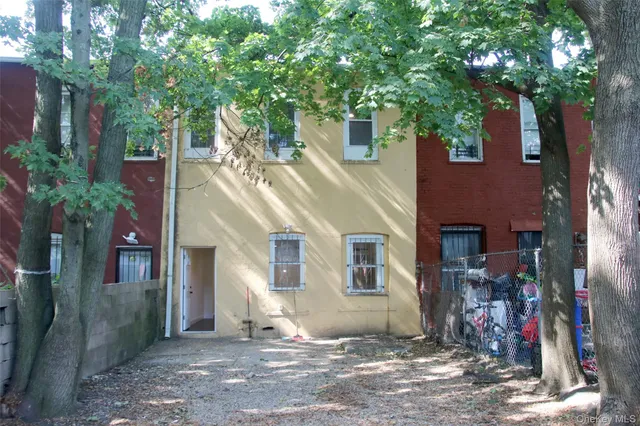 a view of a house with a tree next to a yard