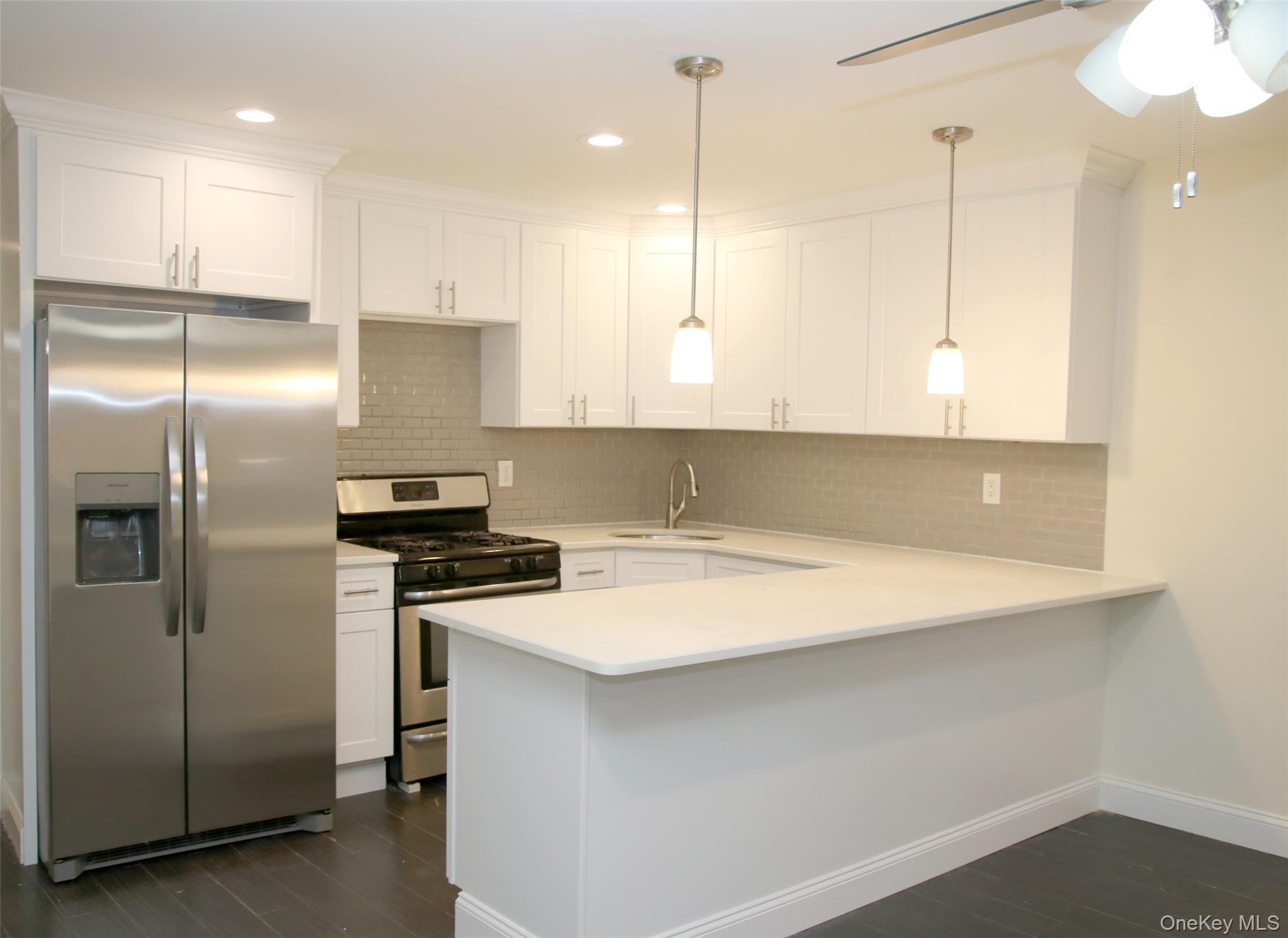 104-07 177th Street Queens, NY 11433 - Photo 4 of 19 a kitchen with stainless steel appliances granite countertop a sink a stove and a refrigerator