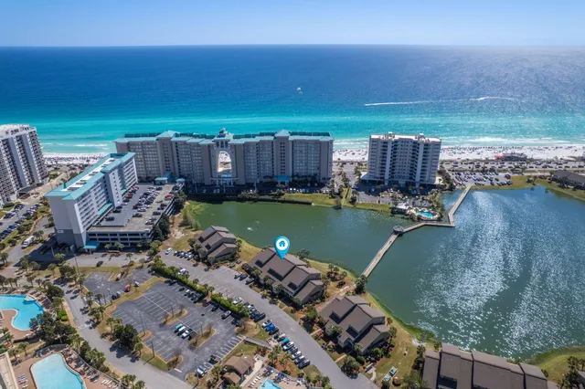 an aerial view of ocean and residential houses with outdoor space