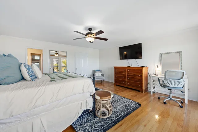 a bedroom with a bed and a flat tv screen on dresser