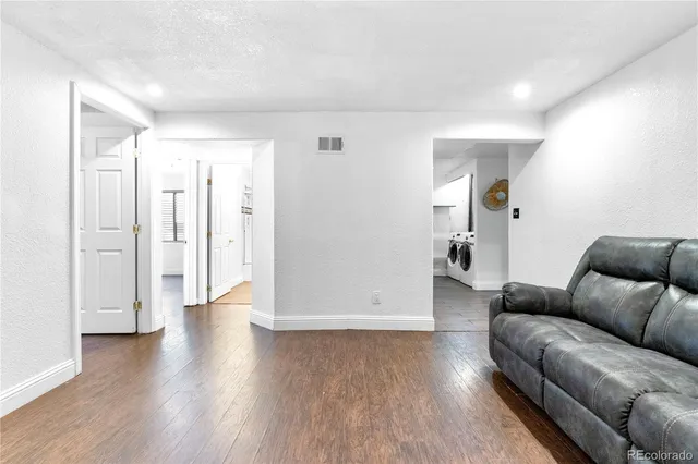 a living room with furniture and wooden floor