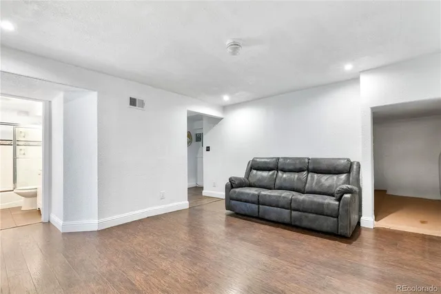 a living room with furniture and a wooden floor