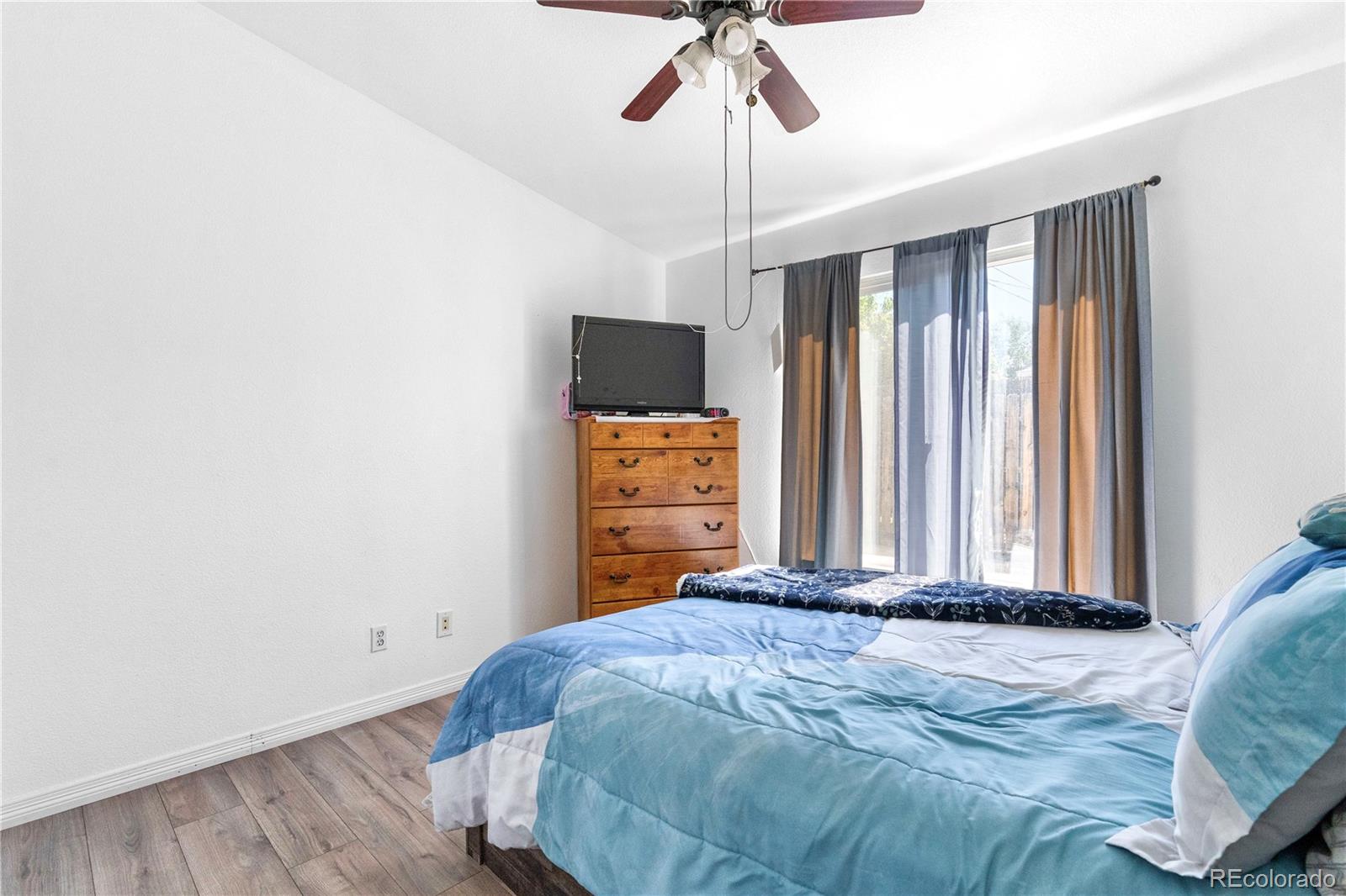 4501 West Alaska Place, Unit B Denver, CO 80219 - Photo 8 of 19 a bedroom with a bed and a chandelier