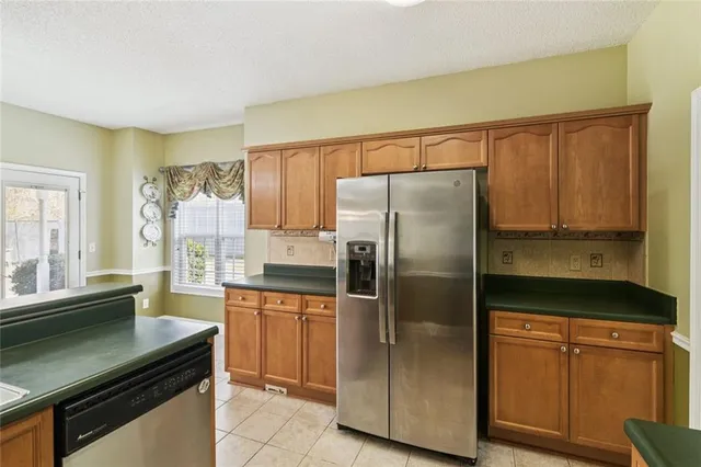 a kitchen with stainless steel appliances granite countertop a refrigerator and a stove