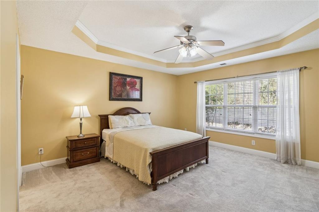 2530 Rosehill Circle Lithia Springs, GA 30122 - Photo 22 of 34 a spacious bedroom with a bed and a chandelier