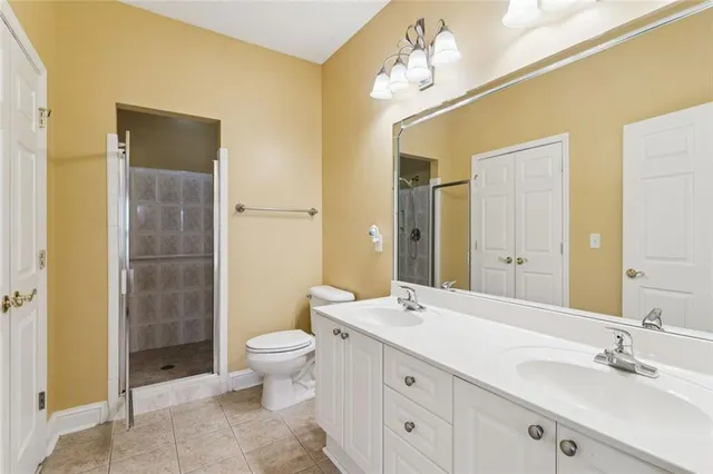 a bathroom with a double vanity sink toilet mirror and shower