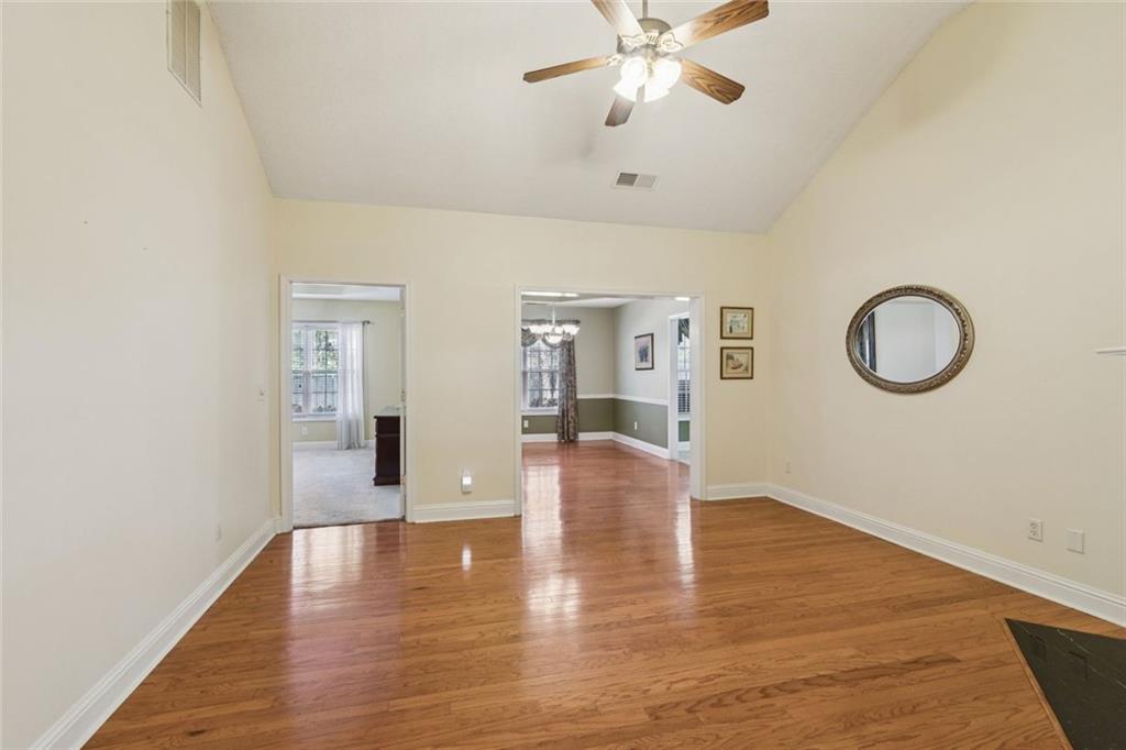 2530 Rosehill Circle Lithia Springs, GA 30122 - Photo 7 of 34 a view of an empty room with wooden floor and a chandelier