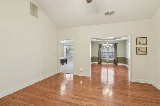 a view of an empty room with wooden floor and a large window
