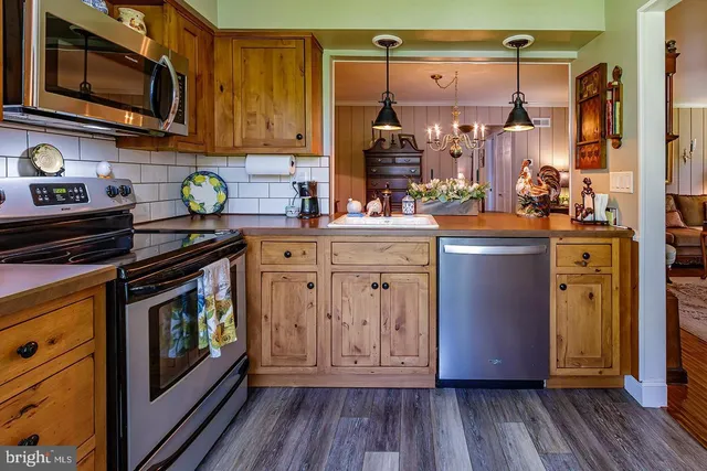 a kitchen with stainless steel appliances granite countertop a refrigerator stove and sink