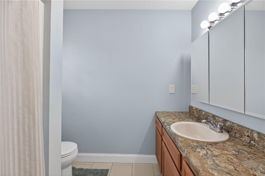 256 Astin Creek Road Villa Rica, GA 30180 - Photo 16 of 38 a bathroom with a granite countertop sink a toilet and a mirror