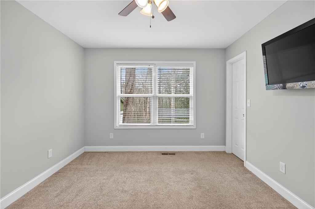 256 Astin Creek Road Villa Rica, GA 30180 - Photo 18 of 38 an empty room with a flat screen tv and windows
