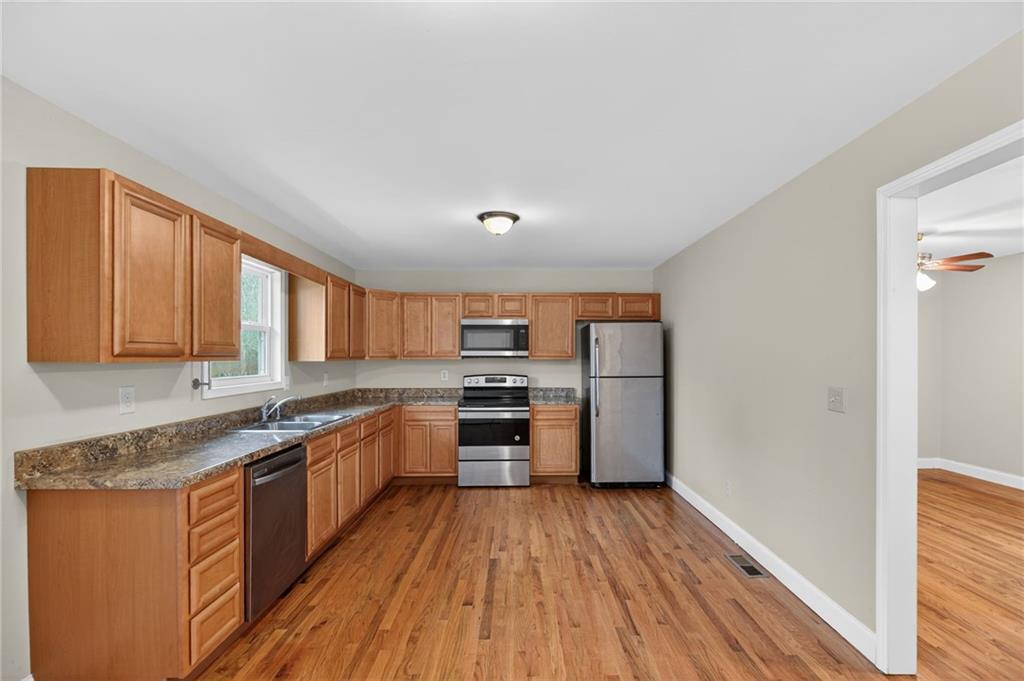 256 Astin Creek Road Villa Rica, GA 30180 - Photo 10 of 38 a kitchen with stainless steel appliances granite countertop a stove cabinets and wooden floor