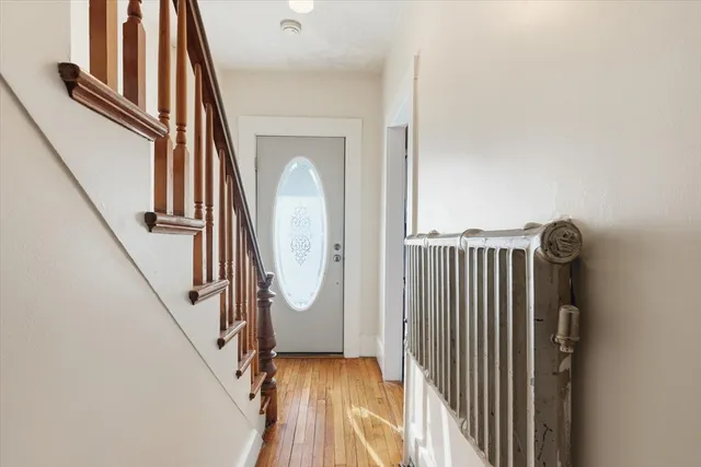 a view of a hallway with wooden floor and staircase