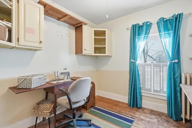 a view of a workspace with furniture and a window