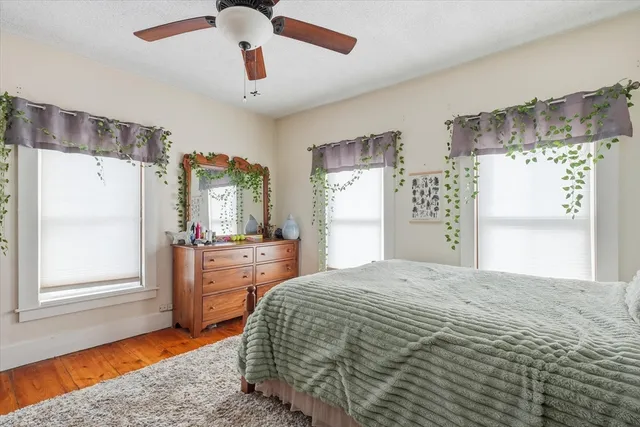 a spacious bedroom with a bed and a dresser next to a window