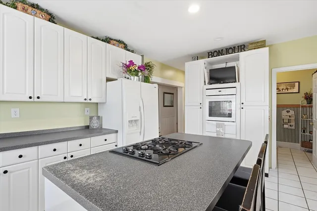 a kitchen with granite countertop a sink stove and refrigerator