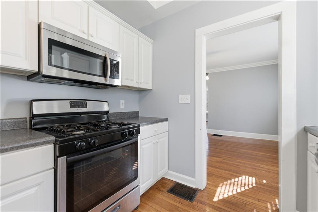 1128 Scott Boulevard Decatur, GA 30030 - Photo 10 of 45 a kitchen with stainless steel appliances white cabinets and a stove top oven