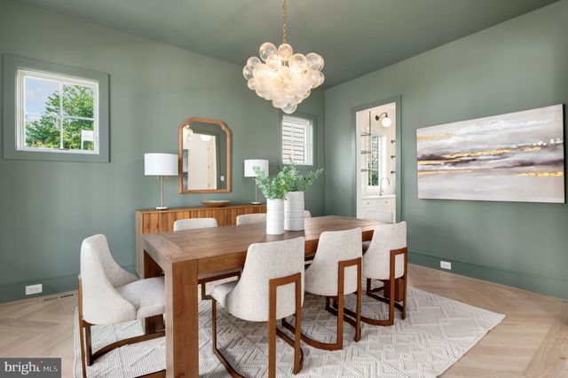 a kitchen with a sink a stove a refrigerator and white cabinets with wooden floor