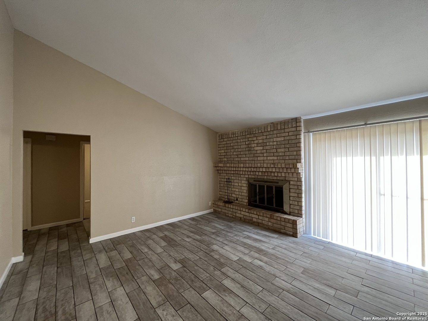 6522 Ridge Willow Drive San Antonio, TX 78233 - Photo 9 of 42 an empty room with wooden floor fireplace and windows
