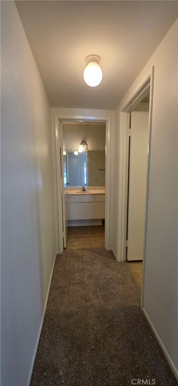 4823 Cobblestone Lane, Unit 24 Cypress, CA 90630 - Photo 13 of 26 a view of a hallway with wooden shelves
