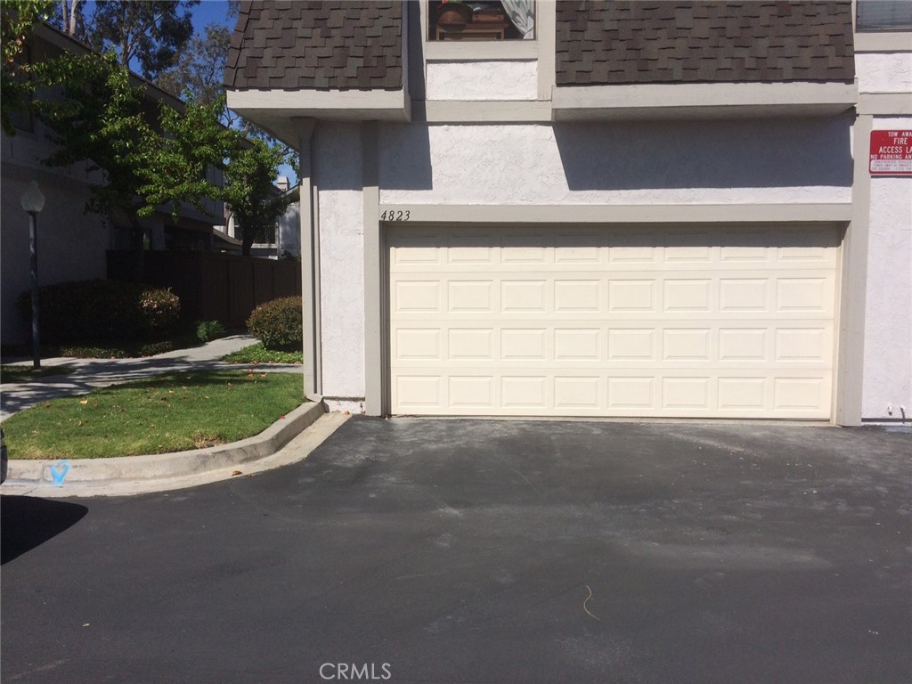 4823 Cobblestone Lane, Unit 24 Cypress, CA 90630 - Photo 24 of 26 a view of a house with a yard and garage
