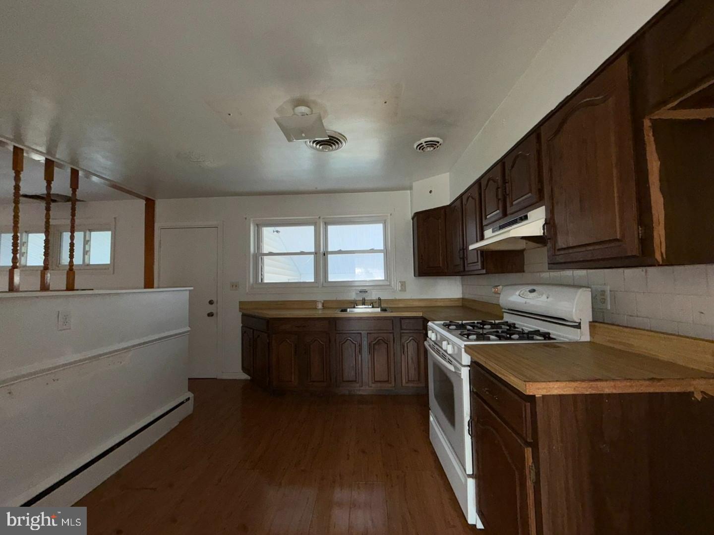 3829 Elmcroft Road Randallstown, MD 21133 - Photo 30 of 56 a kitchen with stainless steel appliances a stove a sink a refrigerator and cabinets
