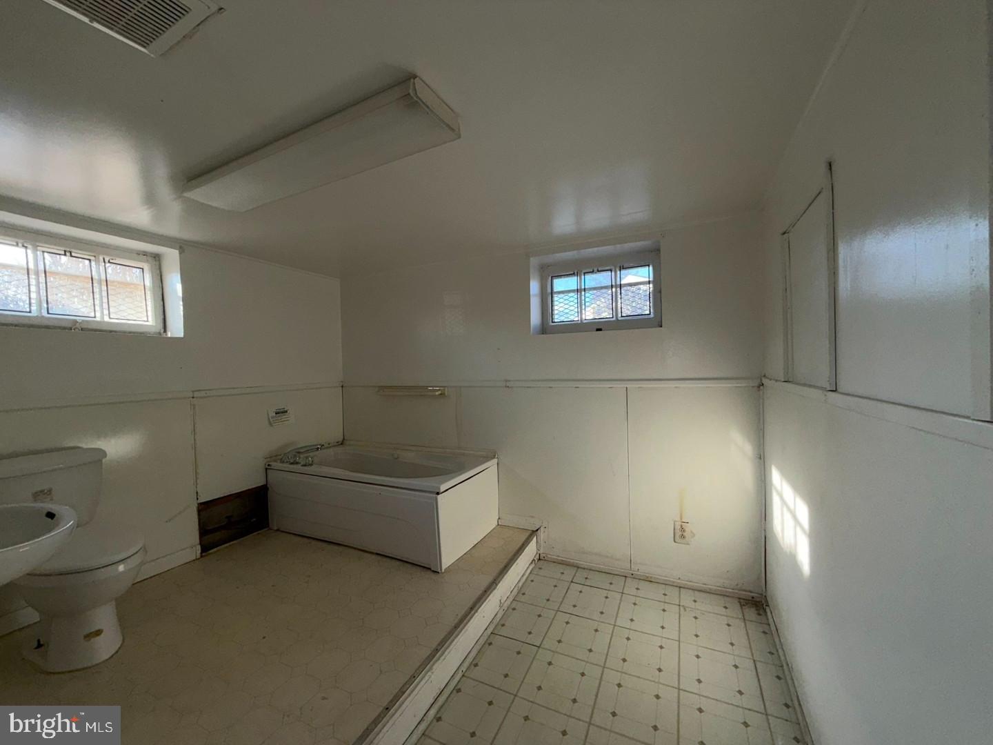 3829 Elmcroft Road Randallstown, MD 21133 - Photo 51 of 56 a bathroom with a toilet a sink and mirror