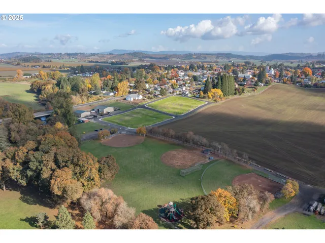 a view of a big yard with lots of green space and car parked