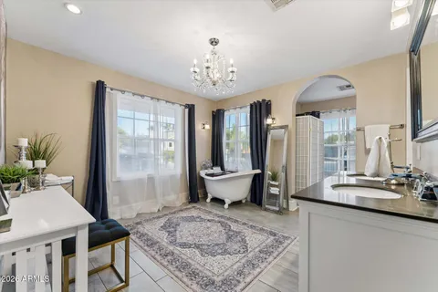 a living room with furniture a chandelier and a large window