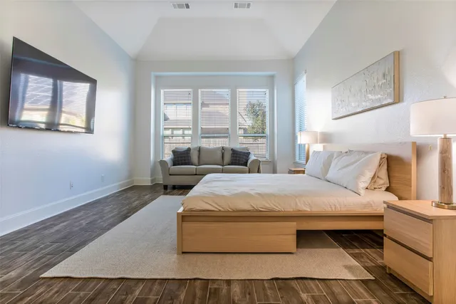 a bedroom with a bed lamp and a large window