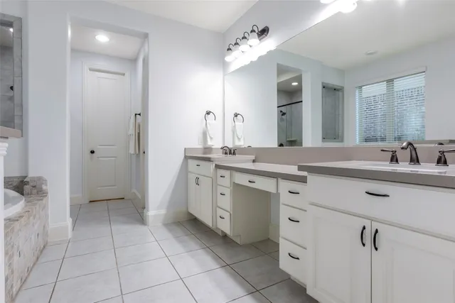 a spacious bathroom with a double vanity sink a mirror and a shower