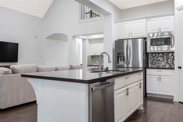 a kitchen with stainless steel appliances granite countertop a sink and a refrigerator