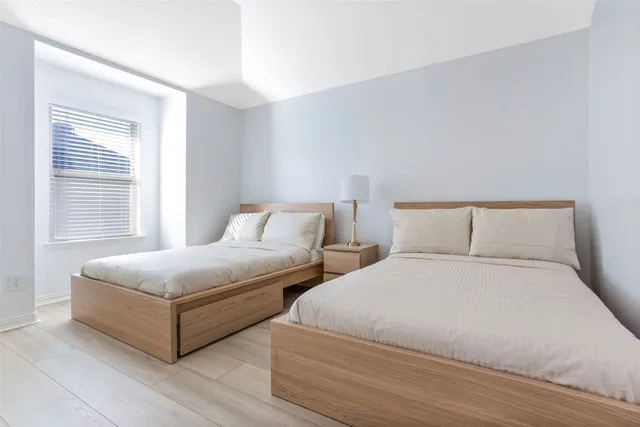 a bedroom with two beds and a window