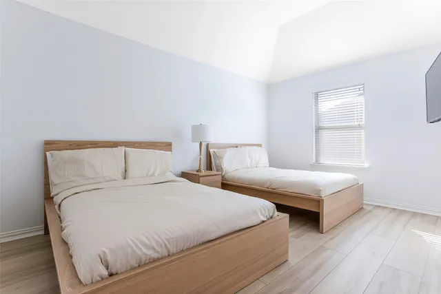 a bedroom with two beds and a night stand