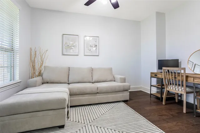 a living room with furniture a rug and a window