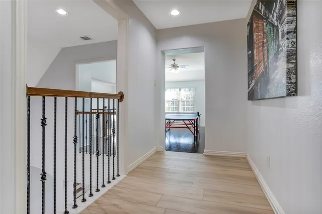 a view of a hallway with wooden floor and a living room