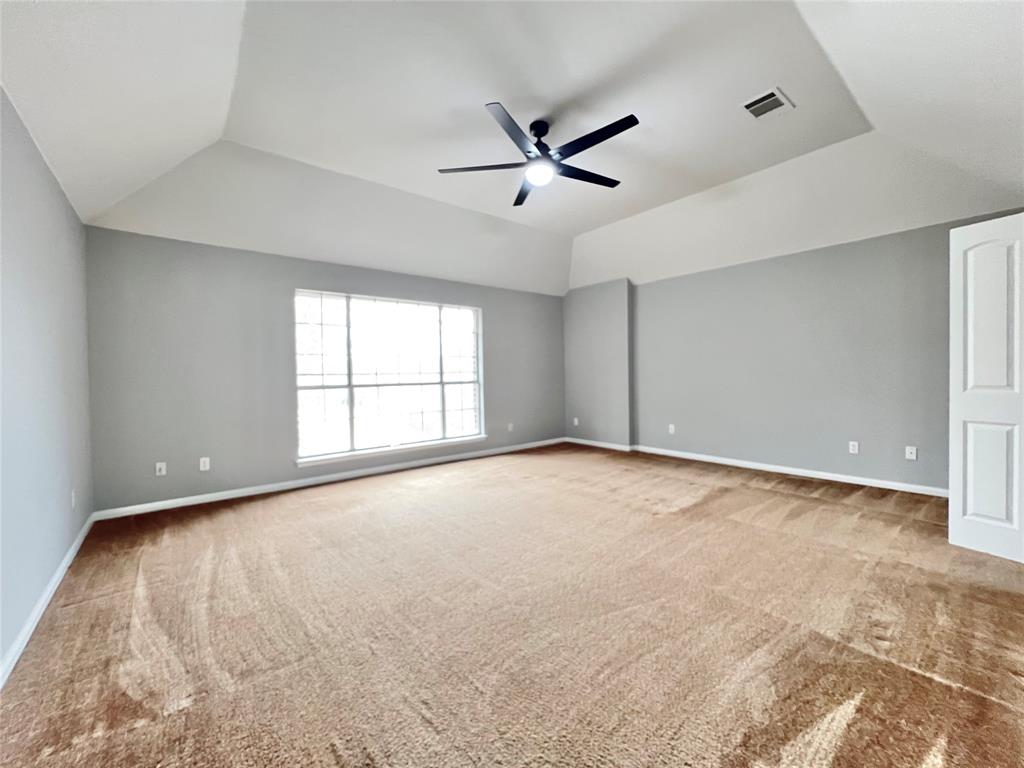 1809 Springwater Drive Round Rock, TX 78681 - Photo 11 of 25 Unfurnished room featuring light colored carpet, a ceiling fan, and lofted ceiling