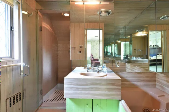 a bathroom with a sink a mirror and shower