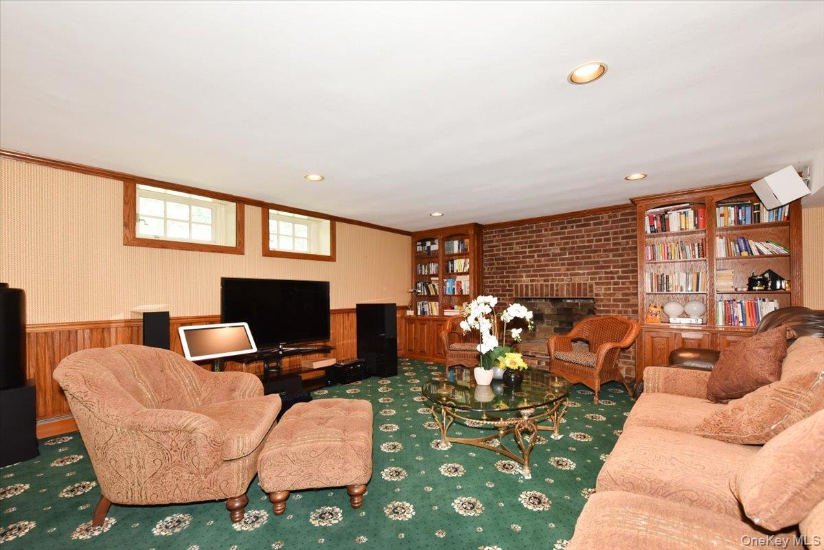 1 Linford Road Great Neck, NY 11021 - Photo 15 of 23 Living area with a brick fireplace, wainscoting, crown molding, recessed lighting, and carpet