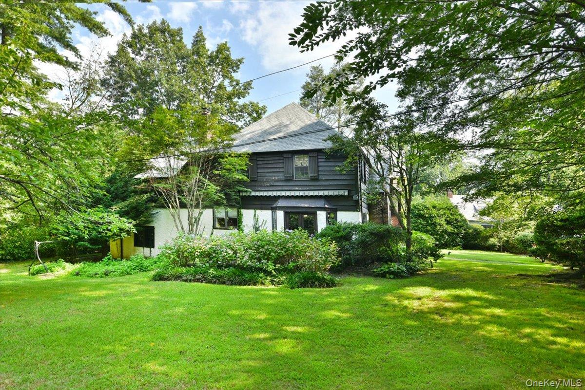 1 Linford Road Great Neck, NY 11021 - Photo 18 of 23 View of side of property with a lawn, roof with shingles, and view of wooded area
