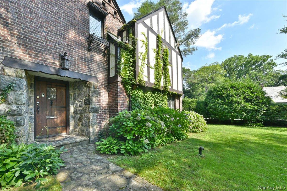 1 Linford Road Great Neck, NY 11021 - Photo 2 of 23 Entrance to property with brick siding, a yard, and stone siding
